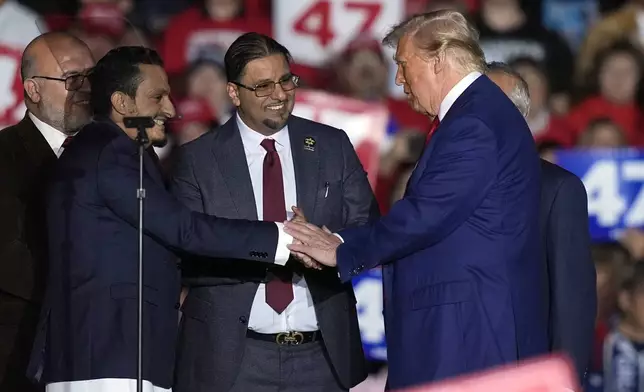 Republican presidential nominee former President Donald Trump, right, greet local Muslim leaders during a campaign rally at the Suburban Collection Showplace, Saturday, Oct. 26, 2024 in Novi, Mich. (AP Photo/Carlos Osorio)