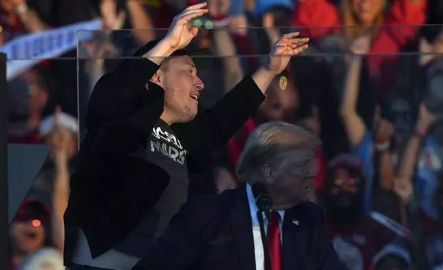 Elon Musk jumps on the stage behind Republican presidential nominee former President Donald Trump during a campaign rally at the Butler Farm Show, Saturday, Oct. 5, 2024, in Butler, Pa. (AP Photo/Julia Demaree Nikhinson)