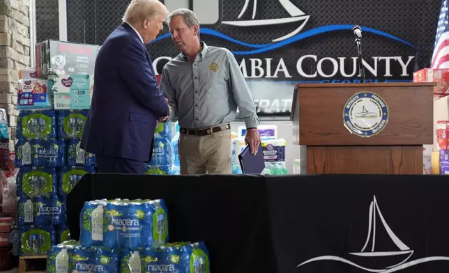 Republican presidential nominee former President Donald Trump shakes hands with Georgia Gov. Brian Kemp at a temporary relief shelter as he visits areas impacted by Hurricane Helene, Friday, Oct. 4, 2024, in Evans, Ga. (AP Photo/Evan Vucci)