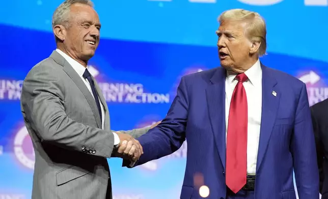 Republican presidential nominee former President Donald Trump shakes hands with Robert F. Kennedy Jr., at a Turning Point Action campaign rally, Wednesday, Oct. 23, 2024, in Duluth, Ga. (AP Photo/Alex Brandon)