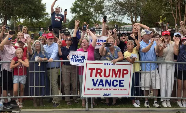 People line the road as Republican presidential nominee former President Donald Trump arrives to speak at a temporary relief shelter as he visits areas impacted by Hurricane Helene, Friday, Oct. 4, 2024, in Evans, Ga. (AP Photo/Evan Vucci)