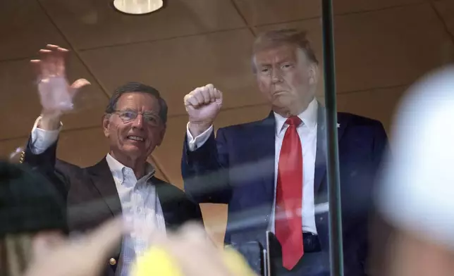 Republican presidential nominee former President Donald Trump attends the Pittsburgh Steelers game against the New York Jets Sunday, Oct. 20, 2024, in Pittsburgh, with Sen. John Barrasso, R-Wyo. (Win McNamee/Pool via AP)