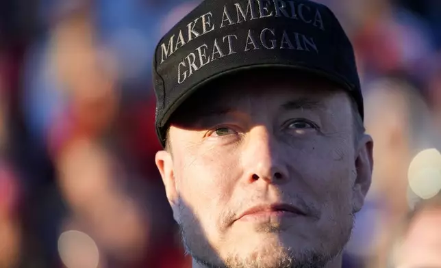 Tesla and SpaceX CEO Elon Musk listens as Republican presidential nominee former President Donald Trump speaks at a campaign event at the Butler Farm Show, Saturday, Oct. 5, 2024, in Butler, Pa. (AP Photo/Alex Brandon)