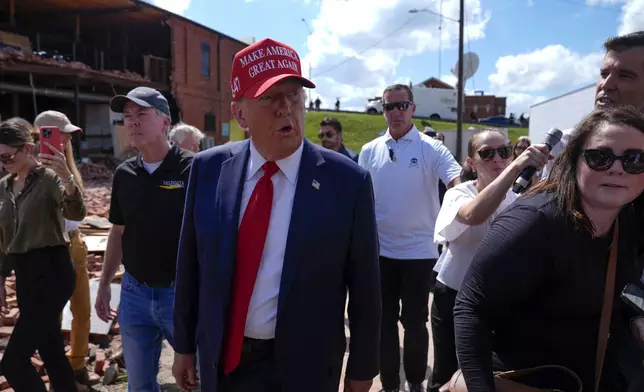 Republican presidential nominee former President Donald Trump walks outside the Chez What furniture store as he visits Valdosta, Ga., a town impacted by Hurricane Helene, Monday, Sept. 30, 2024. (AP Photo/Evan Vucci)