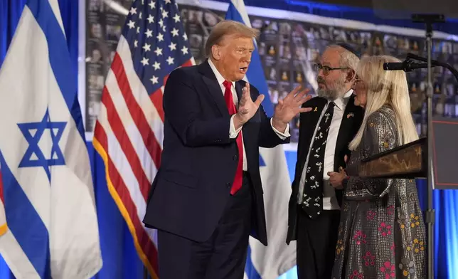 Republican presidential nominee former President Donald Trump talks with Miriam Adelson and Rabbi Yeshuda Kaploun at an event marking one year since the Oct. 7 Hamas attack on Israel, Monday, Oct. 7, 2024, in Miami. (AP Photo/Alex Brandon)