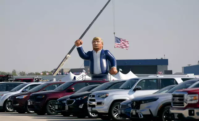 An inflatable Donald Trump is pictured in the parking lot of a campaign rally before the Republican presidential nominee former President arrives to speak at Dodge County Airport, Sunday, Oct. 6, 2024, in Juneau, Wis. (AP Photo/Julia Demaree Nikhinson)