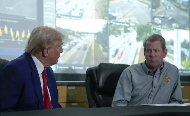 Republican presidential nominee former President Donald Trump talks with Georgia Gov. Brian Kemp during a briefing at the Columbia County Emergency Management Agency as he visits areas impacted by Hurricane Helene, Friday, Oct. 4, 2024, in Evans, Ga. (AP Photo/Evan Vucci)