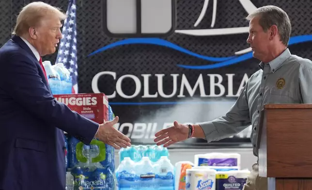 Republican presidential nominee former President Donald Trump shakes hands with Georgia Gov. Brian Kemp at a temporary relief shelter as he visits areas impacted by Hurricane Helene, Friday, Oct. 4, 2024, in Evans, Ga. (AP Photo/Evan Vucci)