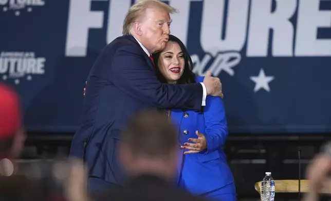 Republican presidential nominee former President Donald Trump, left, hugs Republican House candidate Mayra Flores at a campaign event at Beauty Society, Saturday, Oct. 12, 2024, in North Las Vegas, Nev. (AP Photo/John Locher)