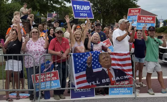 People line the road as Republican presidential nominee former President Donald Trump arrives to speak at a temporary relief shelter as he visits areas impacted by Hurricane Helene, Friday, Oct. 4, 2024, in Evans, Ga. (AP Photo/Evan Vucci)