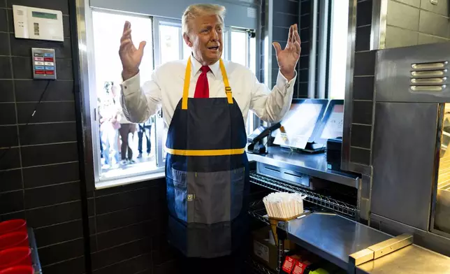 Republican presidential nominee former President Donald Trump stands at a drive-thru window during a campaign stop at a McDonald's in Feasterville-Trevose, Pa., Sunday, Oct. 20, 2024. (Doug Mills/The New York Times via AP, Pool)