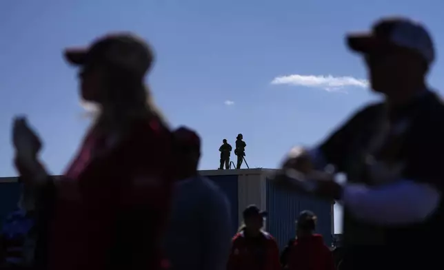 Law enforcement snipers stand on a roof as people wait for Republican presidential nominee former President Donald Trump to speak during a campaign rally at Dodge County Airport, Sunday, Oct. 6, 2024, in Juneau, Wis. (AP Photo/Julia Demaree Nikhinson)