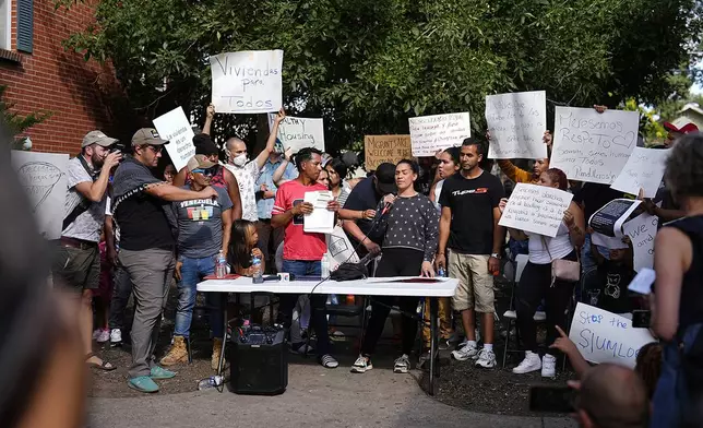 FILE - Juan Carlos Jimenez, center left, and Geraldine Massa speak during a rally by the East Colfax Community Collective to address chronic problems in the apartment buildings occupied by people displaced from their home countries in central and South America, Tuesday, Sept. 3, 2024, in Aurora, Colo. (AP Photo/David Zalubowski, File)