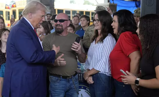 Republican presidential nominee former President Donald Trump greets people at a temporary relief shelter as he visits areas impacted by Hurricane Helene, Friday, Oct. 4, 2024, in Evans, Ga. (AP Photo/Evan Vucci)