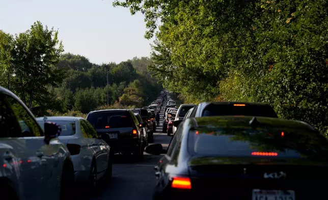 Cars wait in traffic to enter a campaign rally for Republican presidential nominee former President Donald Trump at Dodge County Airport, Sunday, Oct. 6, 2024, in Juneau, Wis. (AP Photo/Julia Demaree Nikhinson)