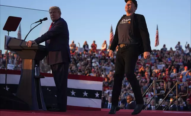 Elon Musk jumps on the stage as Republican presidential nominee former President Donald Trump speaks at a campaign rally at the Butler Farm Show, Saturday, Oct. 5, 2024, in Butler, Pa. (AP Photo/Evan Vucci)