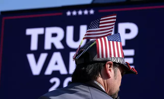 An attendee waits for Republican presidential nominee former President Donald Trump to speak during a campaign rally at Dodge County Airport, Sunday, Oct. 6, 2024, in Juneau, Wis. (AP Photo/Julia Demaree Nikhinson)