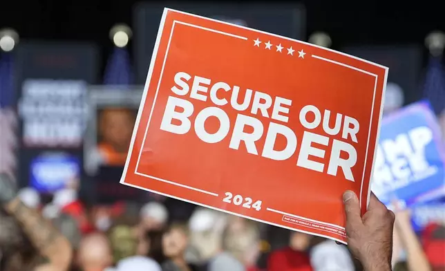 A supporter holds a 'Secure our Border' sign as Republican presidential nominee former President Donald Trump speaks at a campaign rally at the Gaylord Rockies Resort and Convention Center Friday, Oct. 11, 2024, in Aurora, Colo. (AP Photo/David Zalubowski)