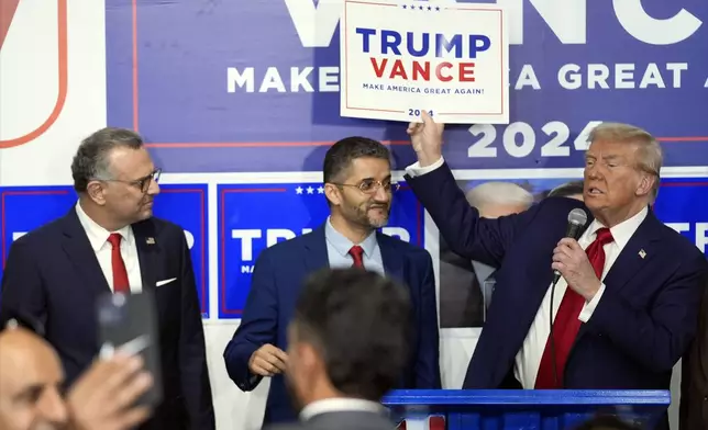 Republican presidential nominee former President Donald Trump speaks as Hamtramck Mayor Amer Ghalib, center, and Massad Boulos, left, listen at a campaign office, Friday, Oct. 18, 2024, in Hamtramck, Mich. (AP Photo/Evan Vucci)