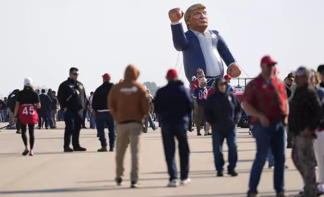 An inflatable Donald Trump is pictured in the parking lot of a campaign rally for the Republican presidential nominee former President as attendees arrive at Dodge County Airport, Sunday, Oct. 6, 2024, in Juneau, Wis. (AP Photo/Julia Demaree Nikhinson)