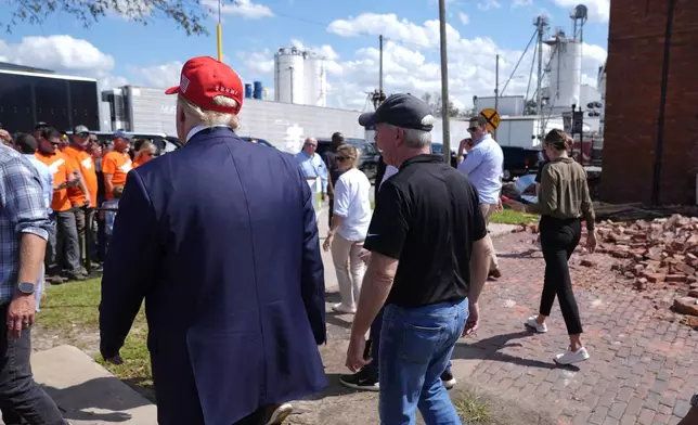 Republican presidential nominee former President Donald Trump walks outside the Chez What furniture store as he visits Valdosta, Ga., a town impacted by Hurricane Helene, Monday, Sept. 30, 2024. (AP Photo/Evan Vucci)