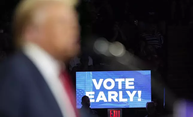 A 'Vote Early' sign is displayed on a monitor as Republican presidential nominee former President Donald Trump speaks at a campaign rally at the Santander Arena, Wednesday, Oct. 9, 2024, in Reading, Pa. (AP Photo/Alex Brandon)