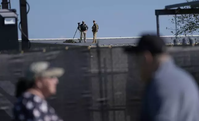 Members of law enforcement stands on a roof before Republican presidential nominee former President Donald Trump speaks at a campaign rally at the Butler Farm Show, the site where a gunman tried to assassinate him in July, Saturday, Oct. 5, 2024, in Butler, Pa. (AP Photo/Alex Brandon)