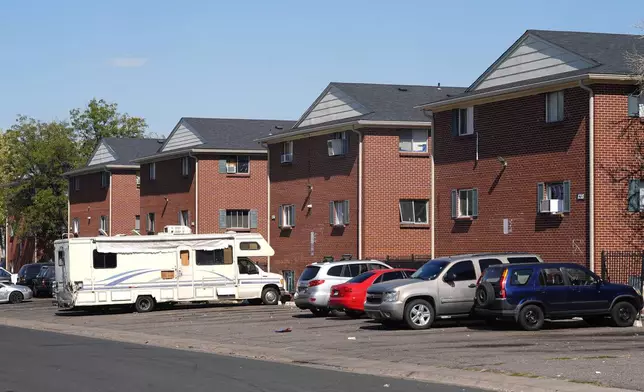 Residents' vehicles sit outside a row of apartment houses occupied by Venezuelans who have migrated to the United States, Wednesday, Oct. 9, 2024, in the east Denver suburb of Aurora, Colo. (AP Photo/David Zalubowski)