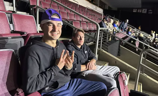 Robert Cabaniss, 28, left, and Taylor Lyze, 25, of Pittsburgh, await the start of a Democratic presidential candidate Vice President Kamala Harris rally at Erie Insurance Arena in Erie, Pa., Monday, Oct. 14, 2024. (AP Photo/Carolyn Thompson)