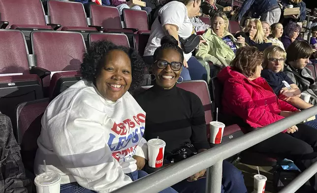 Angela Cox, center, and her adult daughter, Taylor Norton, left, await the start of a Democratic presidential candidate Vice President Kamala Harris rally at the Erie Insurance Arena in Erie, Pa., Monday, Oct. 14, 2024. (AP Photo/Carolyn Thompson)