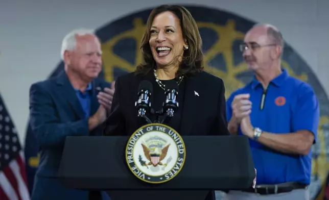 FILE - Democratic presidential nominee Vice President Kamala Harris, with Democratic vice presidential nominee Minnesota Gov. Tim Walz, left, and UAW President Shawn Fain, speaks at a campaign rally at UAW Local 900, Aug. 8, 2024, in Wayne, Mich. (AP Photo/Julia Nikhinson, File)