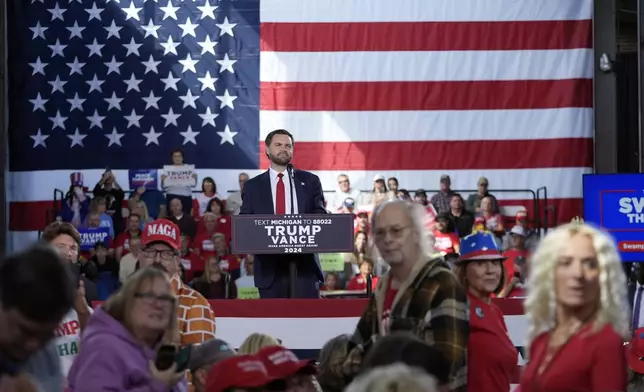 Republican vice presidential nominee Sen. JD Vance, R-Ohio, and supporters listens as reporters ask questions at a campaign event at Eastern Market Tuesday, Oct. 8, 2024, in Detroit. (AP Photo/Paul Sancya)