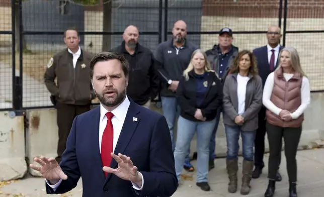 Republican vice presidential nominee Sen. JD Vance, R-Ohio, speaks as law enforcement officers look on in front of the Minneapolis police department's 3rd precinct, which was ransacked and burned after the murder of George Floyd in 2020, Monday, Oct. 14, 2024, in Minneapolis. (AP Photo/Ellen Schmidt)