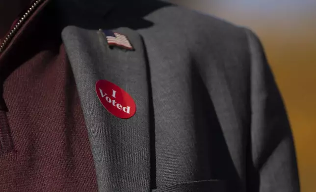 Minnesota Governor and Vice Presidential candidate Tim Walz wears an "I voted sticker" as he speaks to the press after early voting at Ramsey County Elections in St. Paul, Minn., on Wednesday, October 23, 2024. (Renée Jones Schneider/Star Tribune via AP)