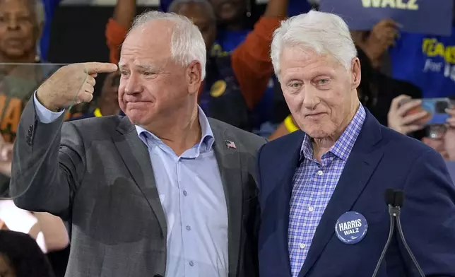 Democratic vice presidential nominee Minnesota Gov. Tim Walz appears with former President Bill Clinton at a campaign rally in Durham, N.C., Thursday, Oct. 17, 2024. (AP Photo/Steve Helber)