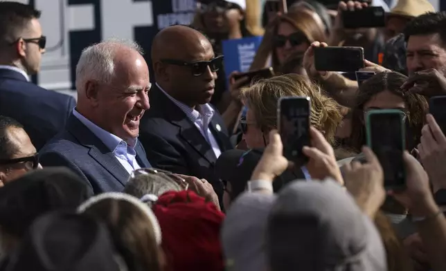 Democratic vice presidential nominee Tim Walz greets members of the crowd at a Harris-Walz campaign's "Fighting for Reproductive Freedom" bus tour stop and canvass kick-off event outside their campaign office in Henderson, Sunday, Oct. 27, 2024. (Rachel Aston/Las Vegas Review-Journal via AP)