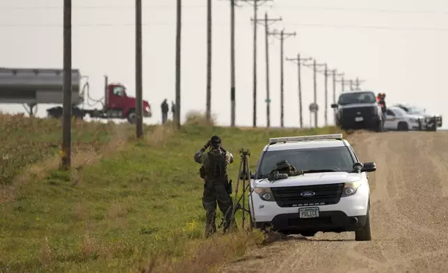 Local police and Secret Service agents surround the area as Tim Walz, Minnesota governor and Democratic vice presidential candidate, takes part in the annual Minnesota Governor's Pheasant Hunting Opener near Sleepy Eye, Minn., Saturday, Oct. 12, 2024. (Anthony Souffle/Star Tribune via AP)