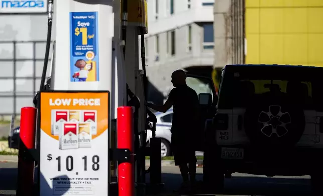 A driver fills up at a pump at a Shell gas station, Wednesday, Oct. 9, 2024, in Seattle. (AP Photo/Lindsey Wasson)