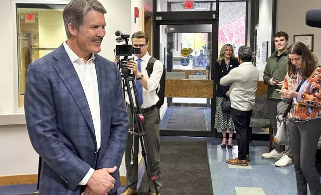 Republican U.S. Senate candidate Eric Hovde chats with reporters as he waits to turn in his ballot at the Village Hall in Shorewood Hills, Wis., Tuesday, Oct. 22, 2024, the first day of early in-person absentee voting in the battleground state. (AP Photo/Todd Richmond)