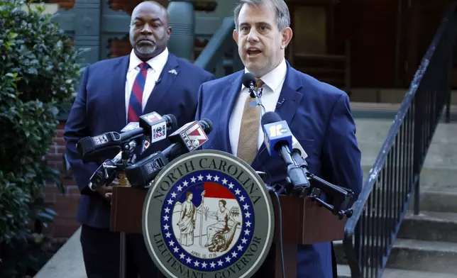 Attorney Jesse Binnall, right, speaks at a news conference, with his client North Carolina Lt. Gov. Mark Robinson, left, in Raleigh, N.C., Tuesday, Oct. 15, 2024. (AP Photo/Karl B DeBlaker)