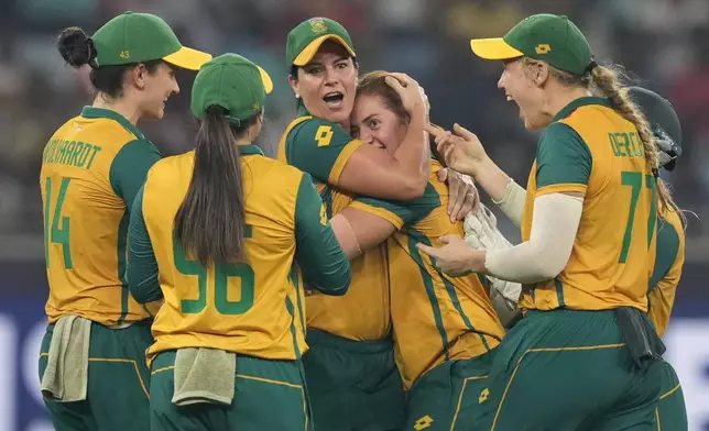 South Africa's Nadine de Klerk, center, without a cap, celebrates with teammates the wicket of New Zealand's captain Sophie Devine during the ICC Women's T20 World Cup 2024 final match between New Zealand and South Africa at Dubai, United Arab Emirates, Sunday, Oct. 20, 2024. (AP Photo/Altaf Qadri)