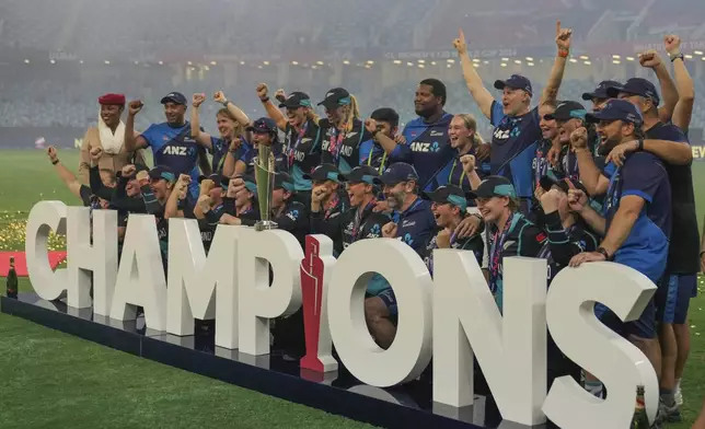 New Zealand's team poses with the trophy after winning the ICC Women's T20 World Cup 2024 final match against South Africa at Dubai International Cricket Stadium, United Arab Emirates, Sunday, Oct. 20, 2024. (AP Photo/Altaf Qadri)