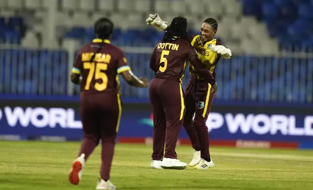 West Indies' Deandra Dottin, center, celebrates with teammates after the dismissal of New Zealand's Maddy Green during the ICC Women's T20 World Cup 2024 semi-final match between New Zealand and West Indies at Sharjah Stadium, United Arab Emirates, Friday, Oct. 18, 2024. (AP Photo/Altaf Qadri)