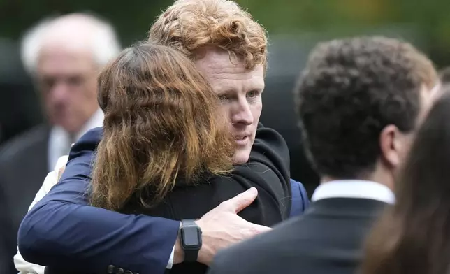 Joseph Kennedy III, center right, grandson of Ethel Kennedy, hugs fellow mourners following funeral services at Our Lady of Victory church for Ethel Kennedy, Monday, Oct. 14, 2024, in Centerville, Mass. (AP Photo/Steven Senne)