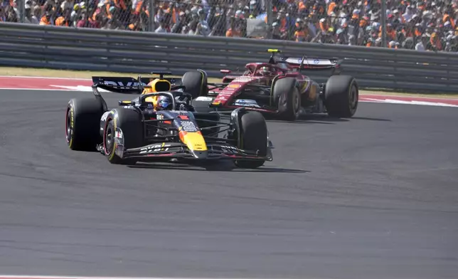 Red Bull driver Max Verstappen, of the Netherlands, leads Ferrari driver Carlos Sainz, of Spain, through a turn during U.S. Grand Prix auto race at Circuit of the Americas, Sunday, Oct. 20, 2024, in Austin, Texas. (AP Photo/Eric Gay)