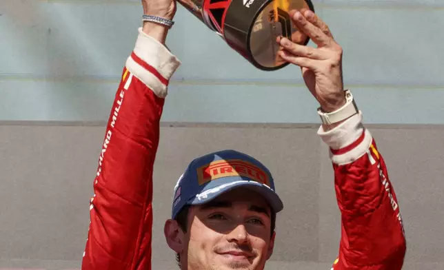 Ferrari driver Charles Leclerc, of Monaco, holds the trophy after winning the U.S. Grand Prix auto race at Circuit of the Americas, Sunday, Oct. 20, 2024, in Austin, Texas. (AP Photo/Nick Didlick)