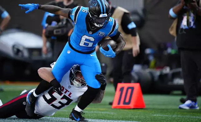 Atlanta Falcons linebacker Nate Landman (53) tackles Carolina Panthers running back Miles Sanders (6) in the first half of an NFL football game in Charlotte, N.C., Sunday, Oct. 13, 2024. (AP Photo/Jacob Kupferman)