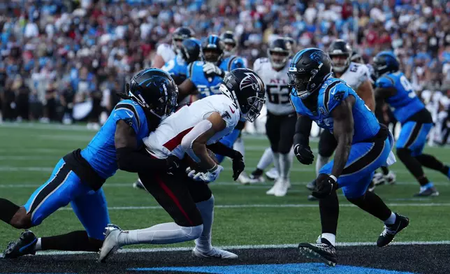 Atlanta Falcons wide receiver Drake London (5) scores a touchdown against Carolina Panthers cornerback Jaycee Horn (8) in the first half of an NFL football game in Charlotte, N.C., Sunday, Oct. 13, 2024. (AP Photo/Jacob Kupferman)