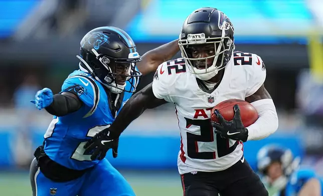 Atlanta Falcons cornerback Clark Phillips III (22) returns a punt against Carolina Panthers cornerback Chau Smith-Wade (26) in the first half of an NFL football game against the in Charlotte, N.C., Sunday, Oct. 13, 2024. (AP Photo/Rusty Jones)