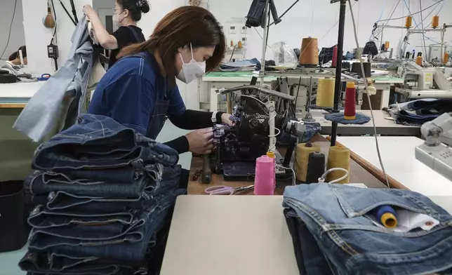 A seamstress works on denim trousers at Momotaro Jeans using a vintage sewing machine in Kojima, Okayama prefecture, western Japan, on Sept. 4, 2024. (AP Photo/Ayaka McGill)